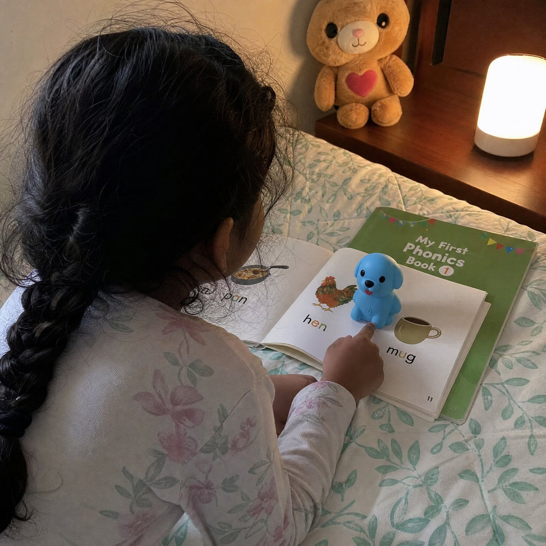 A child using the Puppy Reader with a My First Phonics book