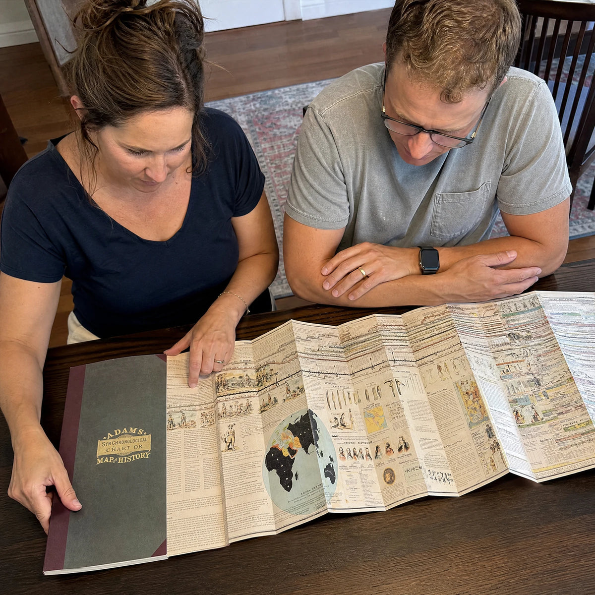 Two adults exploring the chart together at a table