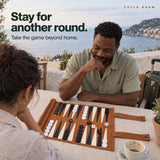 Stay for another round. Adults playing travel backgammon on a scenic outdoor terrace.