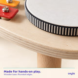 Close-up of the wooden music station's plywood grain, rounded edge and instrument construction